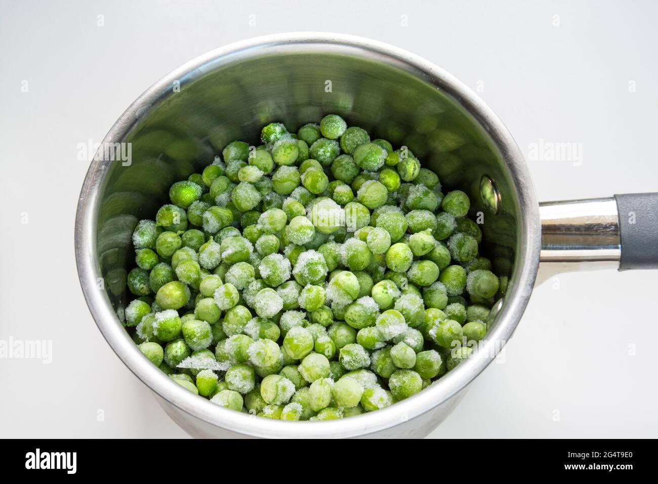 Frozen green peas in a pot to boil Stock Photo Alamy