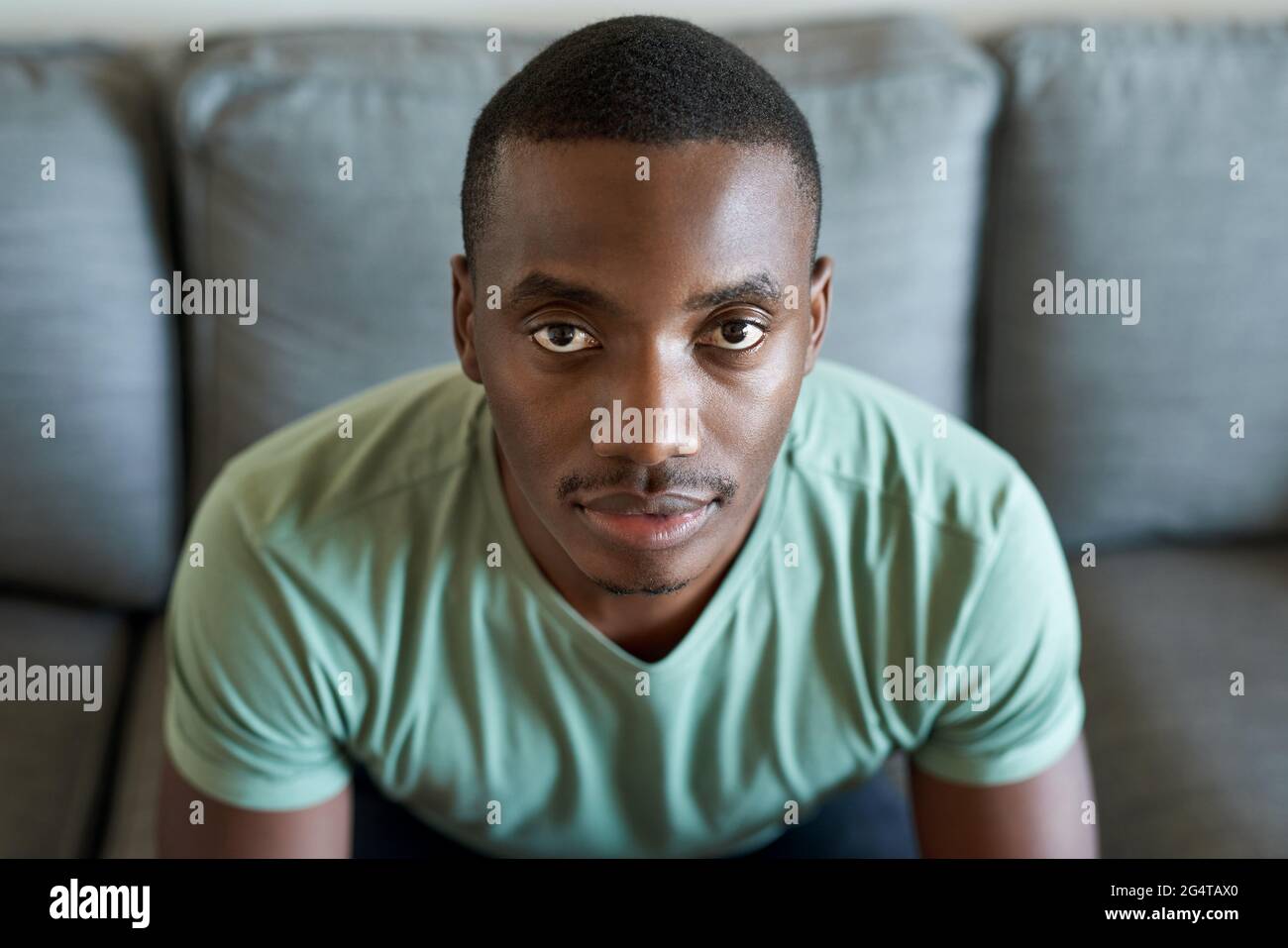 Confident young African man sitting on his living room sofa Stock Photo