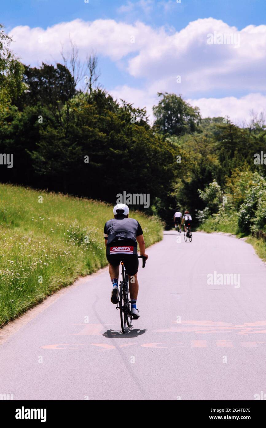 Cyclists cycling back to camera on zig zag road up to top of National