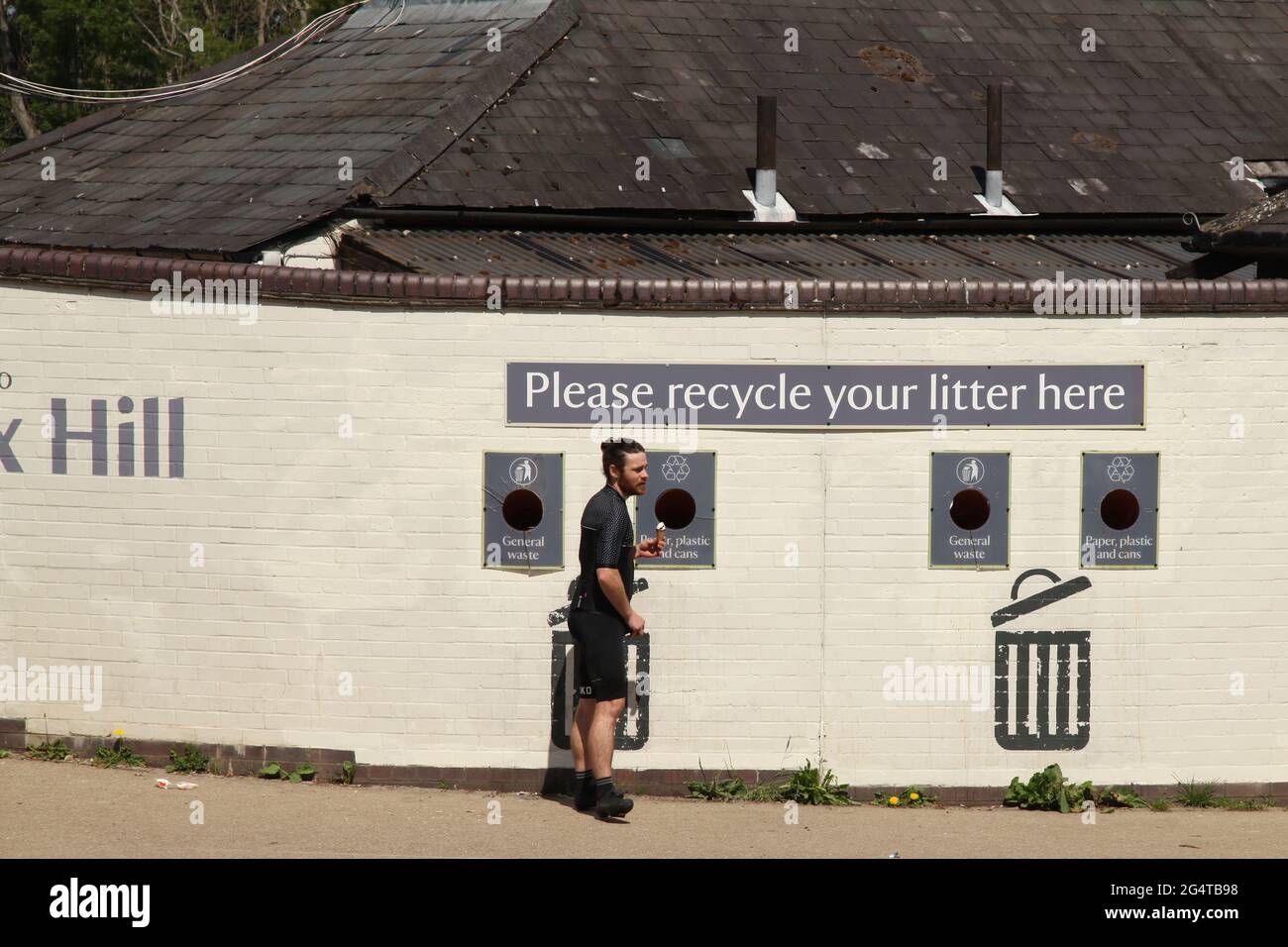 Cyclist recycling a plastic water bottle at top of National Trust Box