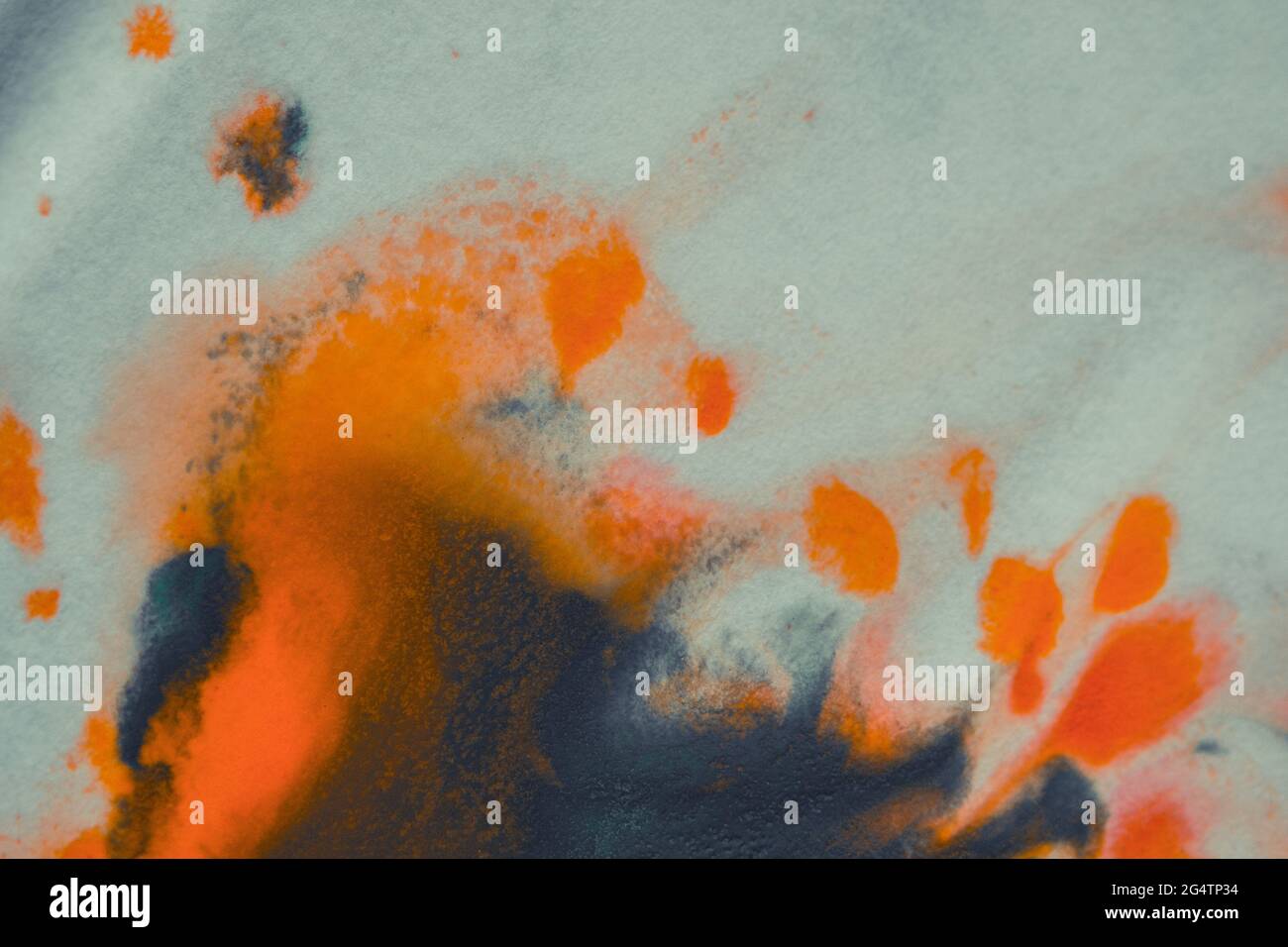 overflowing bright orange and dark blue paint on paper Stock Photo