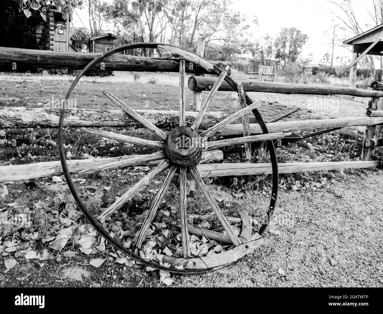 An old Broken Wagon wheel in black and white, in the late afternoon sun in Escalante, Utah USA Stock Photo