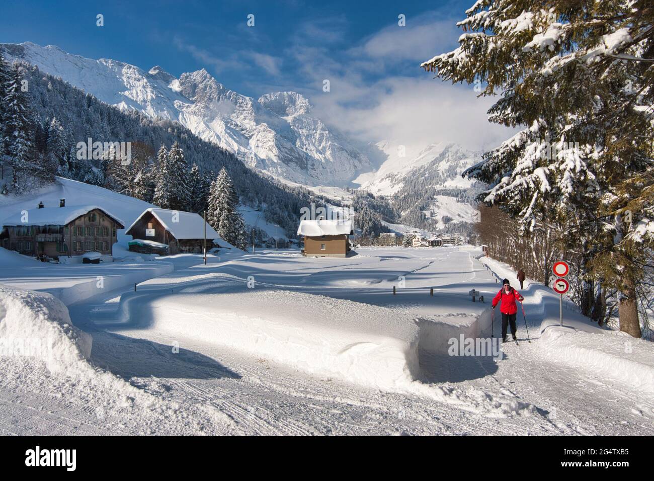 A landscape of a sunlit snow covered field with mountain backdrop at Engelberg, Obwalden canton, central Switzerland Stock Photo