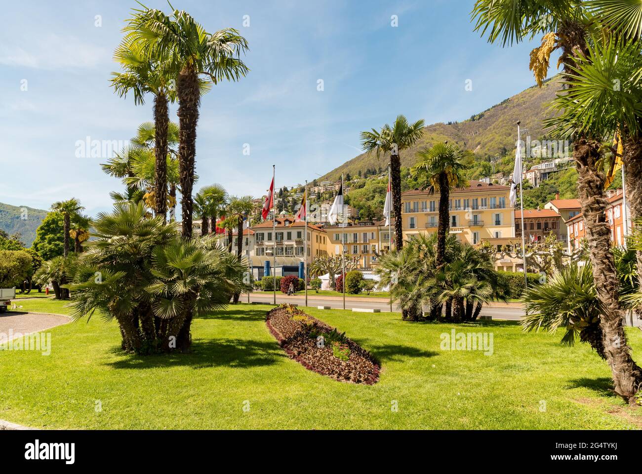 Green gardens decorated with palm trees and flowers at springtime in the center of Locarno, Ticino, Switzerland Stock Photo