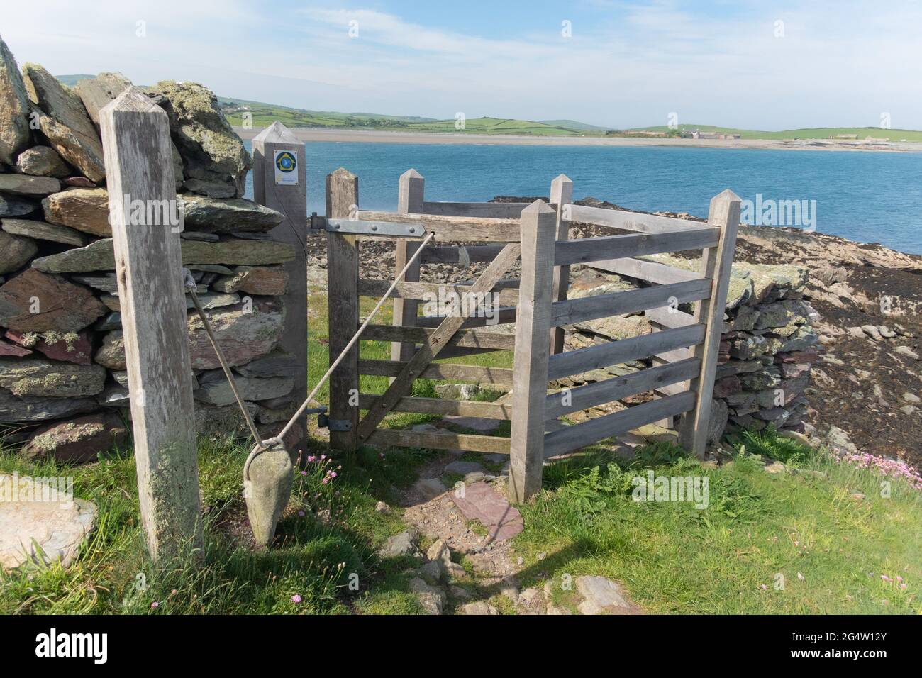 A wooden field gate with a selfclosing mechanism using a small boulder