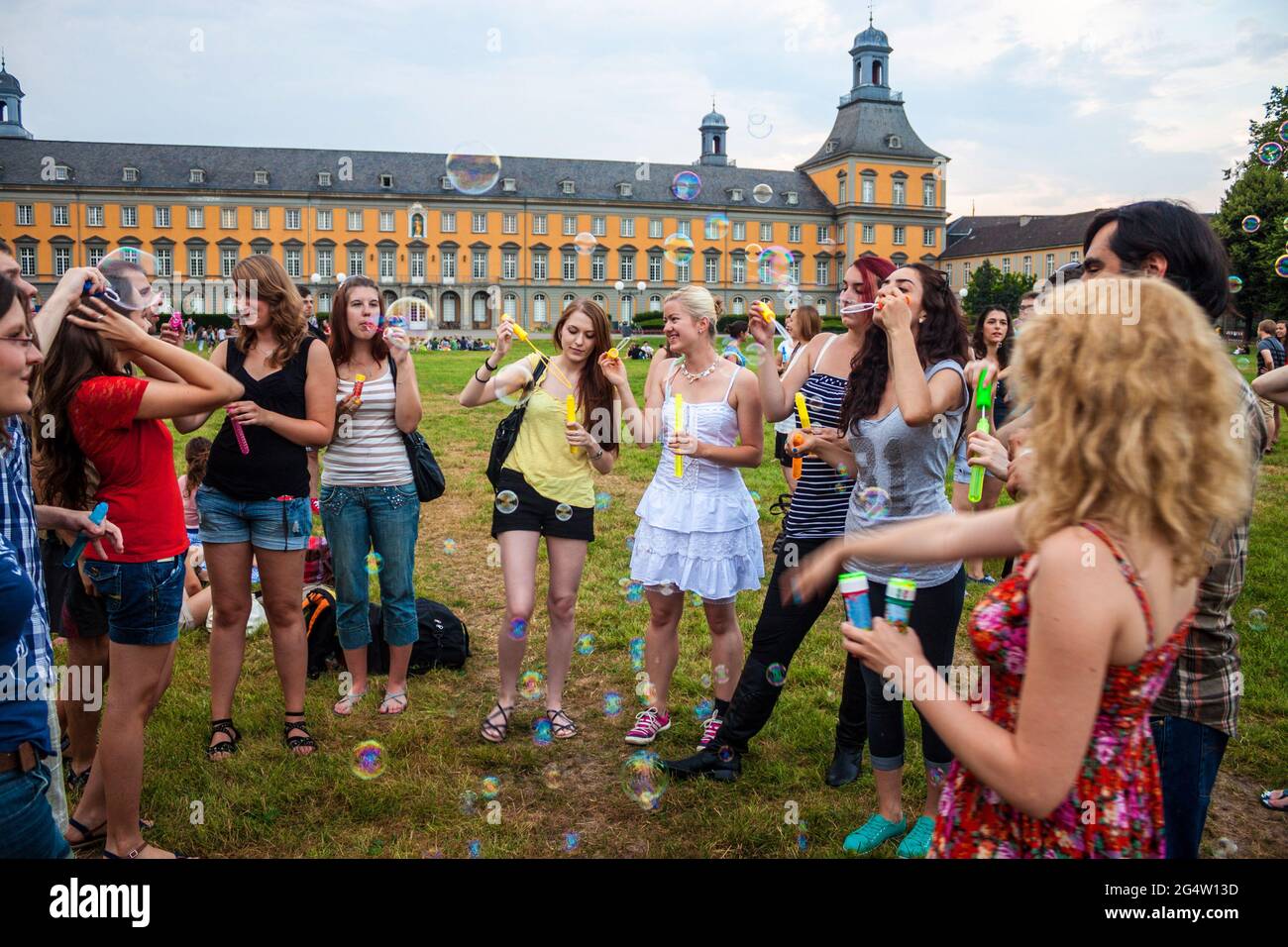 BONN, GERMANY - JULY 22: Students of University in Bonn blow bubbles in front of main building of University on July 22, 2013 in Bonn, Germany. Univer Stock Photo