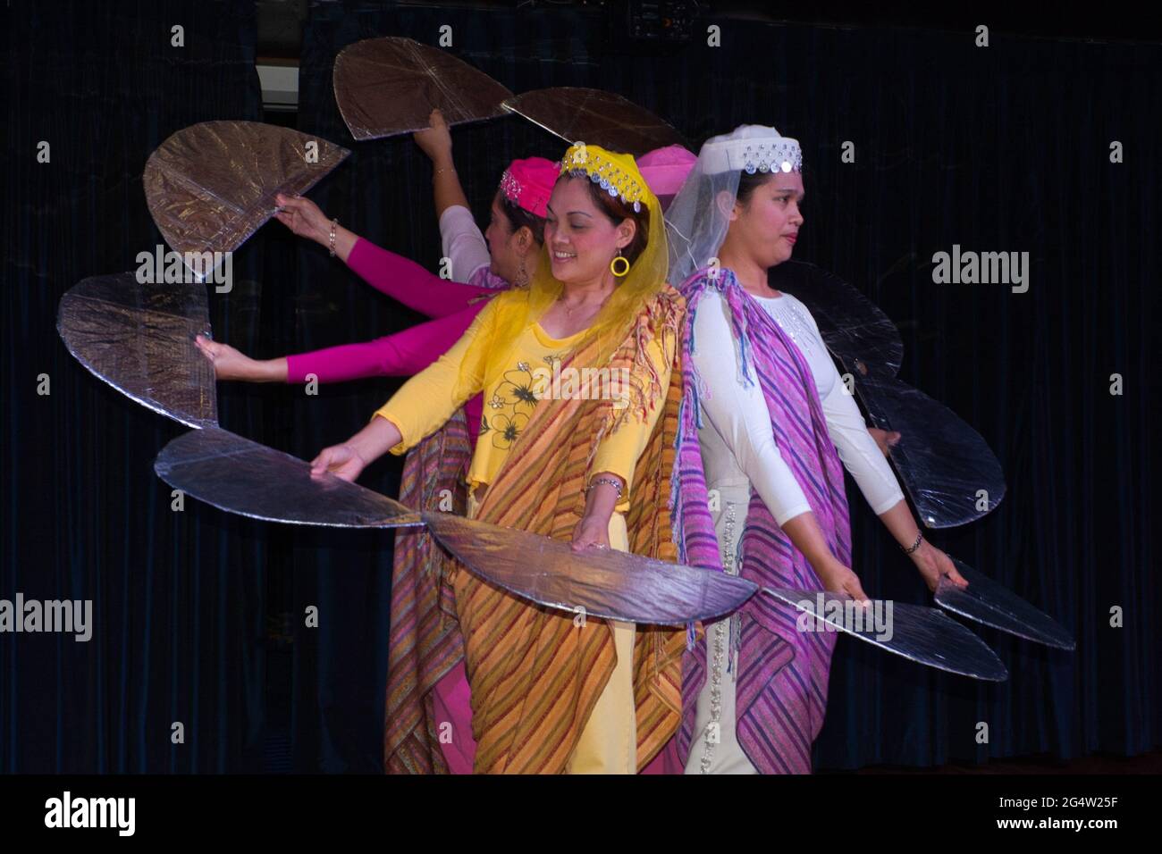 A group of Filipina ladies in saris perform a dance routine on board a cruise ship Stock Photo