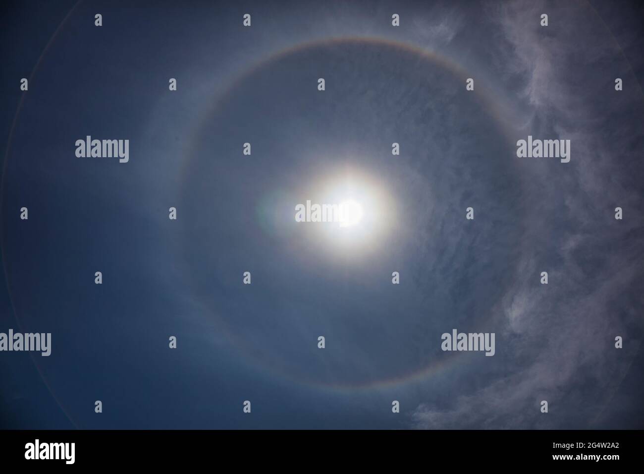 A weather phenomena when the sun has a circular rainbow around it Stock Photo