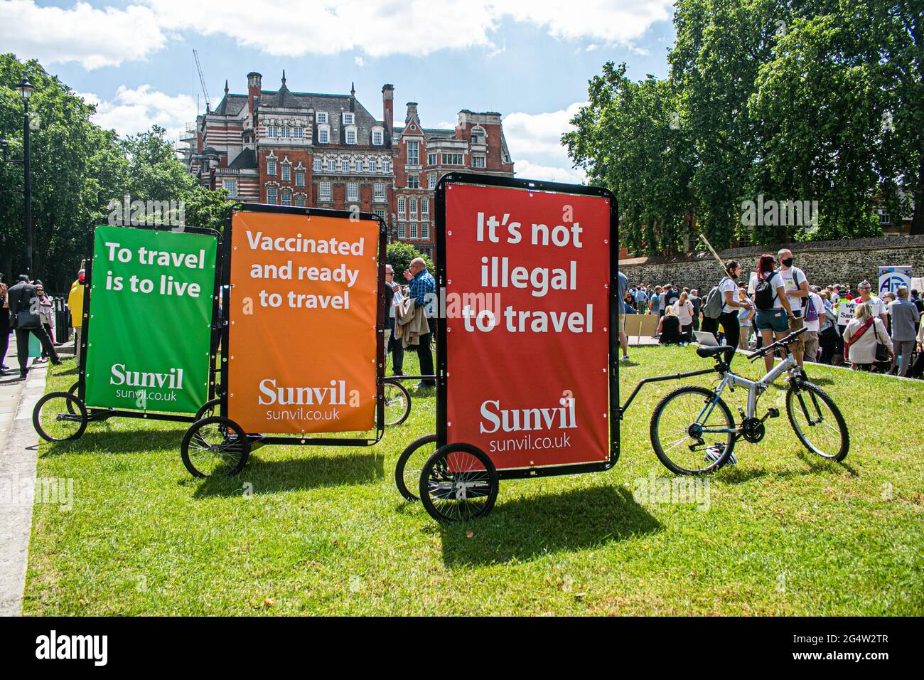 WESTMINSTER LONDON 23 June 2021. Banners on bikes read from left to right, To travel is to live , Vaccinated and read to travel, It's not illegal to travel, during the Travel Day of Action protest in Westminster today to pressure the UK Government to change course and the safe re-opening of international travel  to thousands of British holiday makers and to give financial support for  businesses  in the travel sector which have not been able to trade for well over a year due to the coronavirus restricitions . Credit amer ghazzal/Alamy Live News Stock Photo