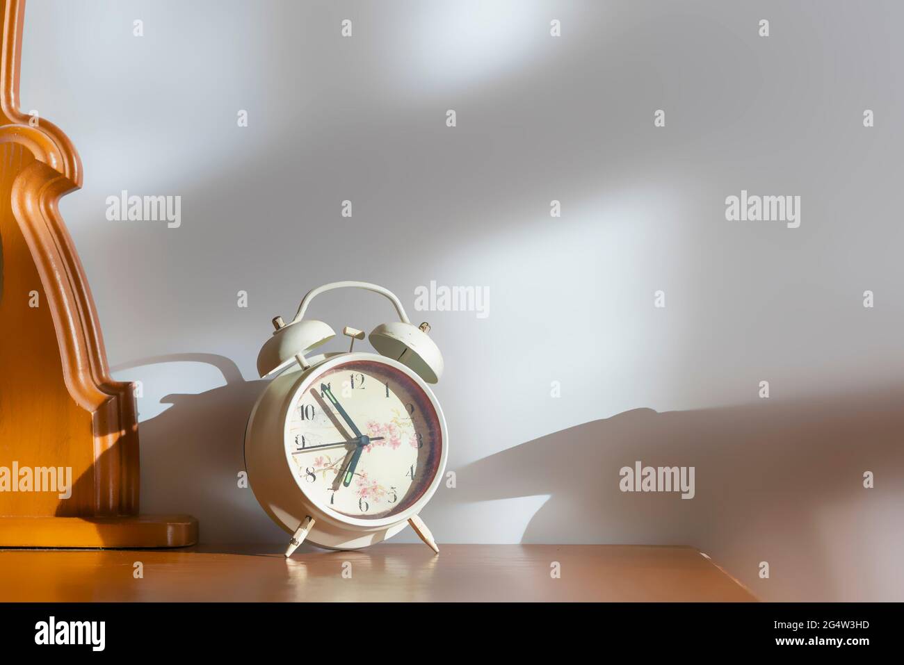 white retro alarm clock on nightstand at morning Stock Photo Alamy