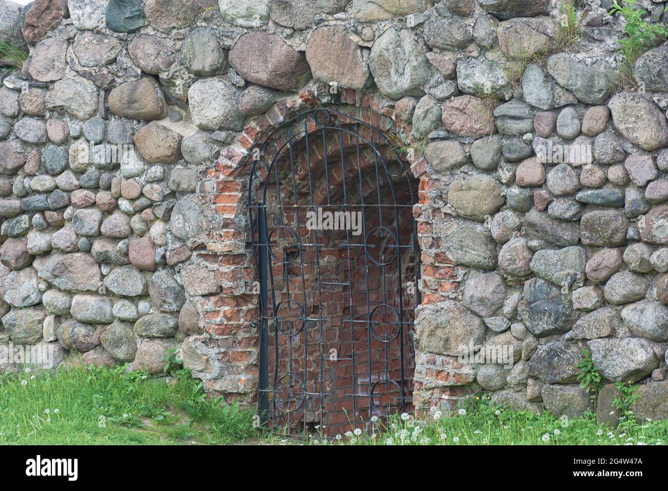 opening in the stone wall is closed with a latticework. Stock photography Stock Photo