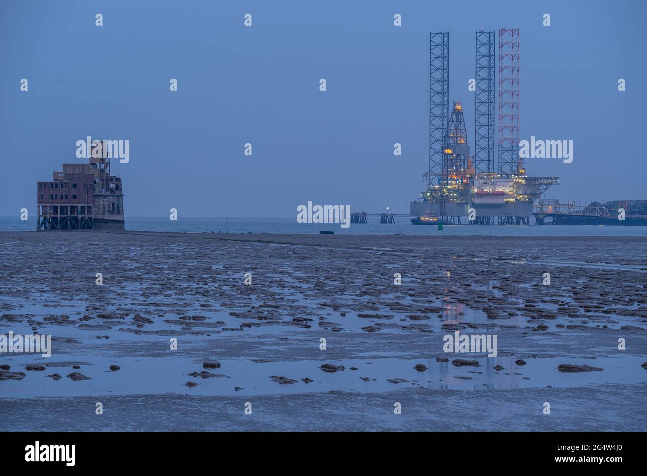 Grain fort in the Swale with drilling rig moored at Sheerness in the background taken at night. Stock Photo
