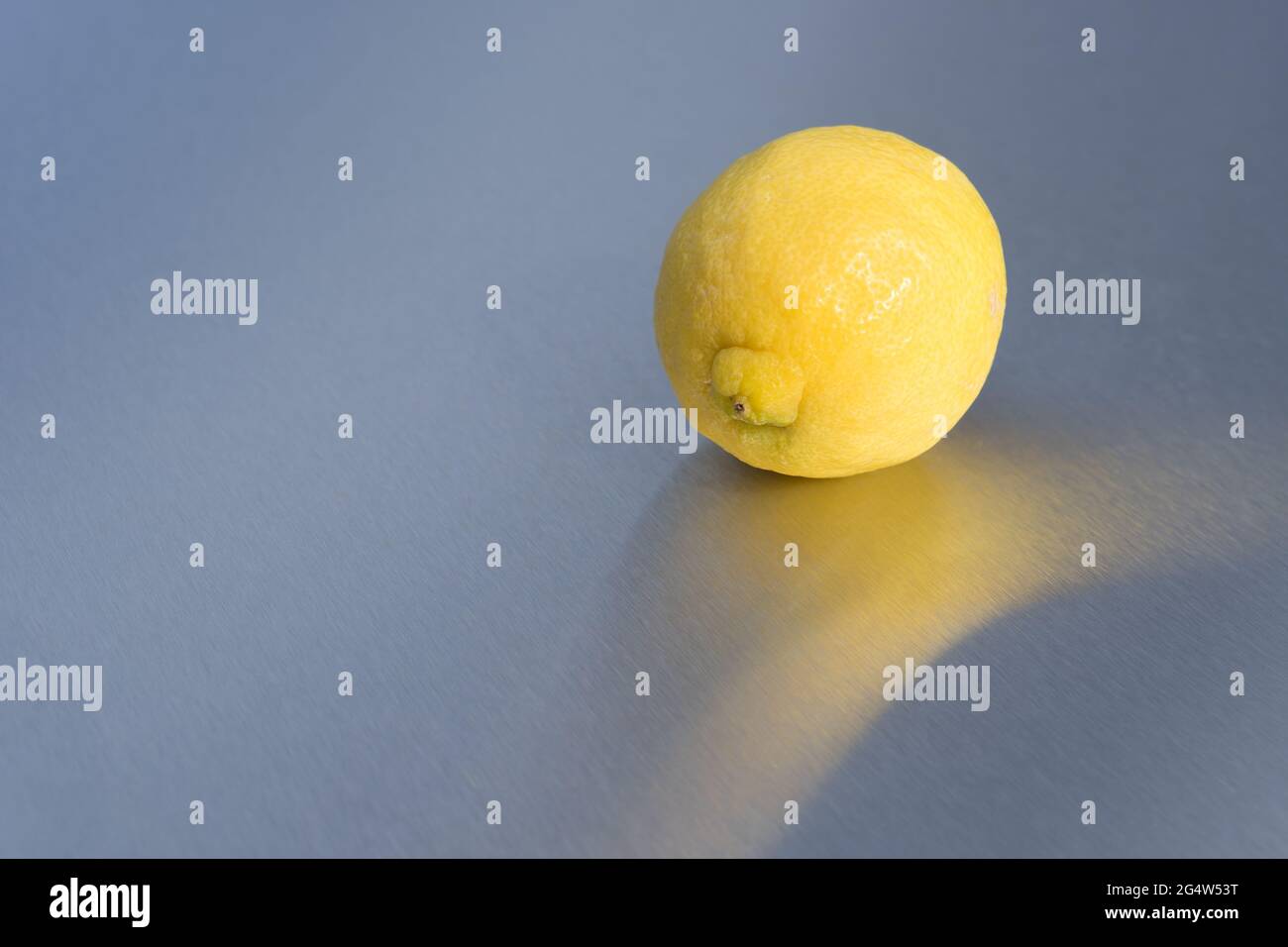 minimalist bright yellow lemon and reflection on clean background sunny fruit Stock Photo