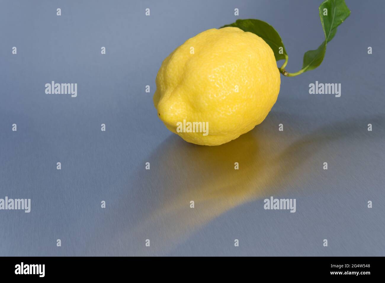 healthy sunny yellow lemon and green leaf and reflection on clean background Stock Photo