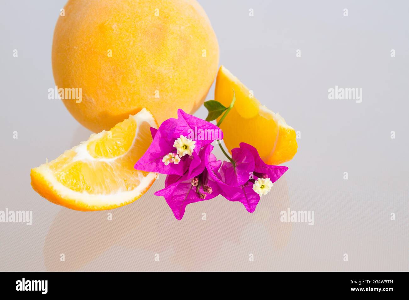 fresh orange slices beautiful pink flowers and ripe yellow peach Stock Photo