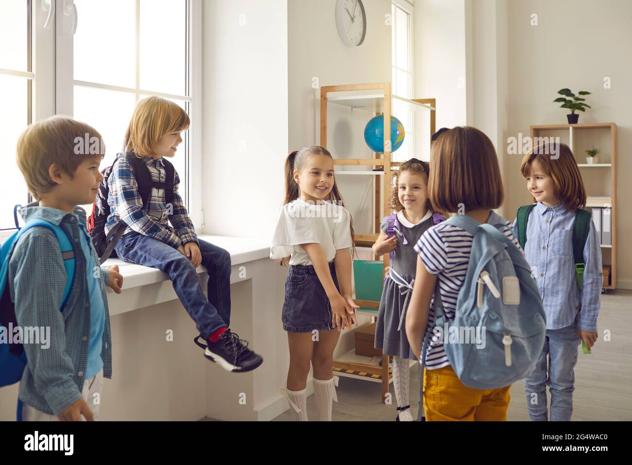 Group of little school children standing in the classroom and talking to each other Stock Photo
