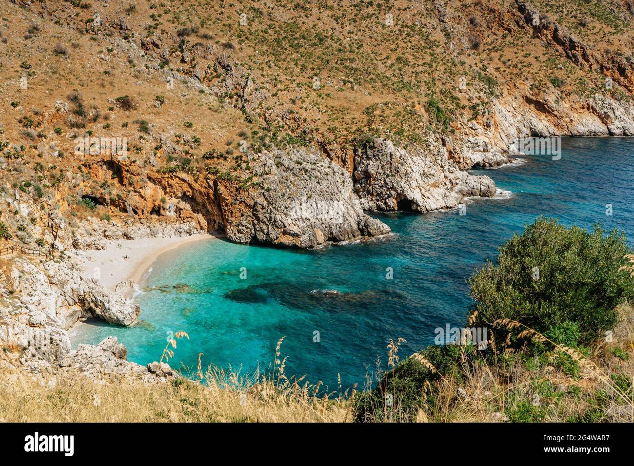 Beach vacation in Sicily,Italy, turquoise water,empty sandy beach in Zingaro Nature Reserve.Holiday paradise travel scenery.Scenic coastline with rock Stock Photo