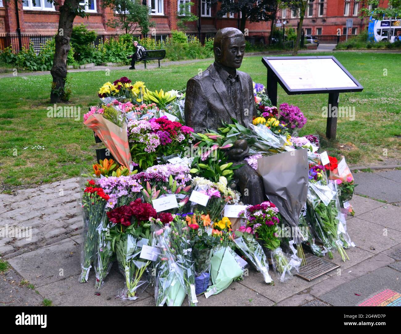 Flowers surround the Alan Turing statue and memorial, Sackville Gardens, Manchester, England, Britain, United Kingdom, on 23rd June, 2021, the anniversary of Turing's birthday. Alan Mathison Turing OBE was an English mathematician, computer scientist, logician, and cryptanalyst. In WW2 he led a team that was responsible for breaking German ciphers of the Enigma machine. Turing was then influential in developing computer science at the University of Manchester. Stock Photo