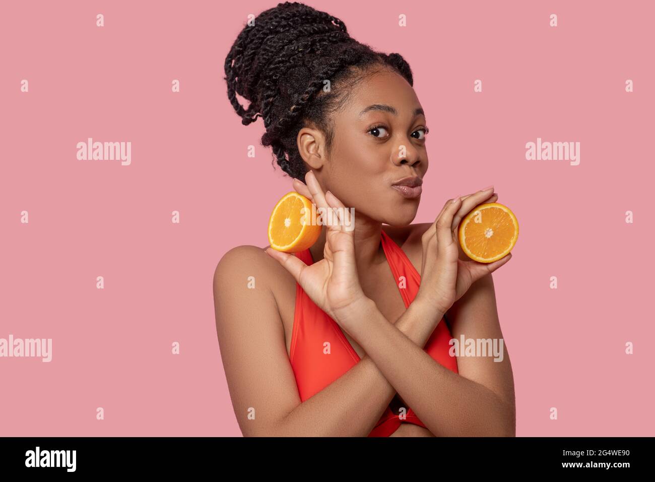 Cute african american woman with slices of orange in hands Stock Photo ...