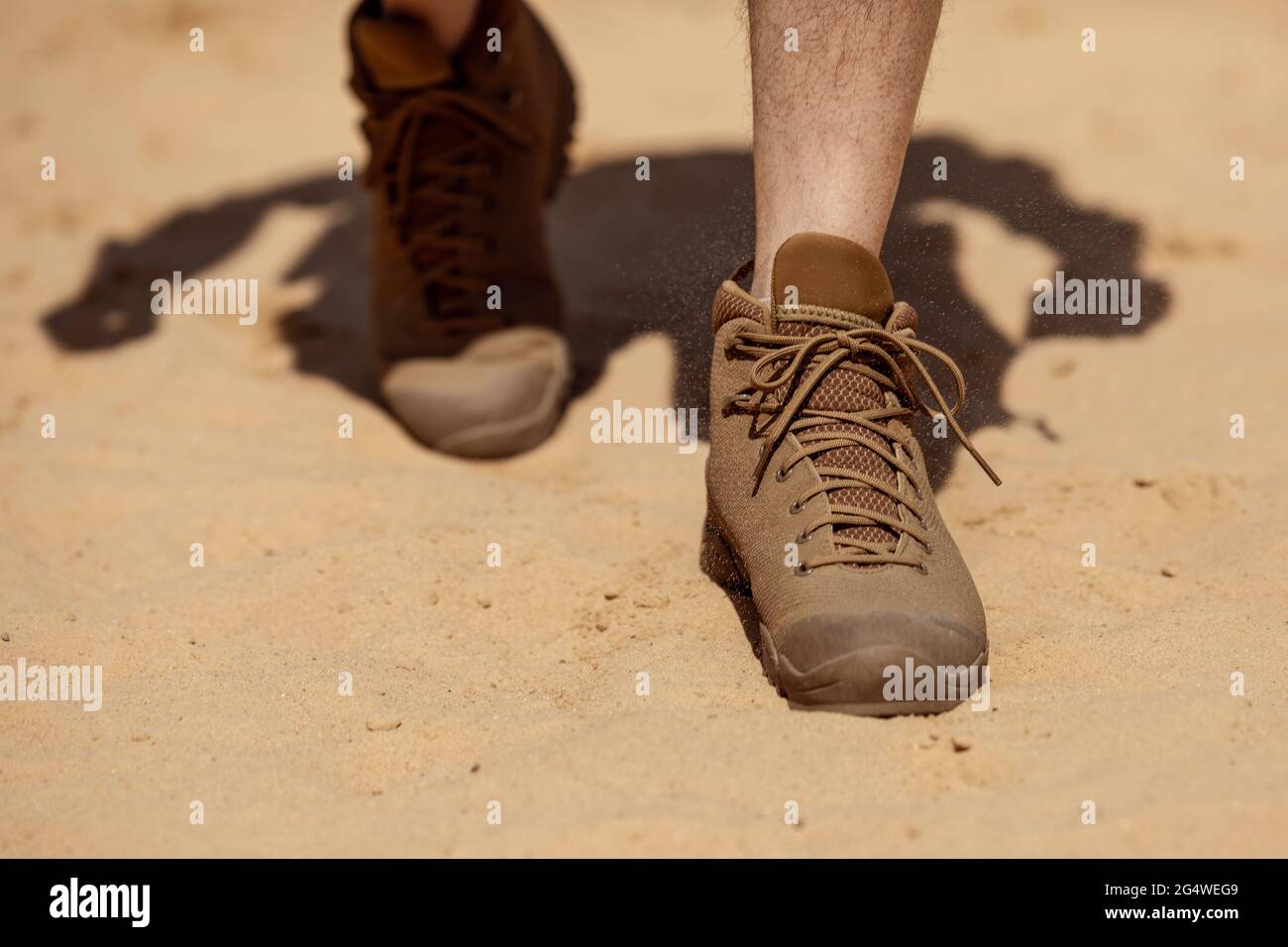 Close up of man legs walking in tactical shoes on sand surface Stock Photo  - Alamy