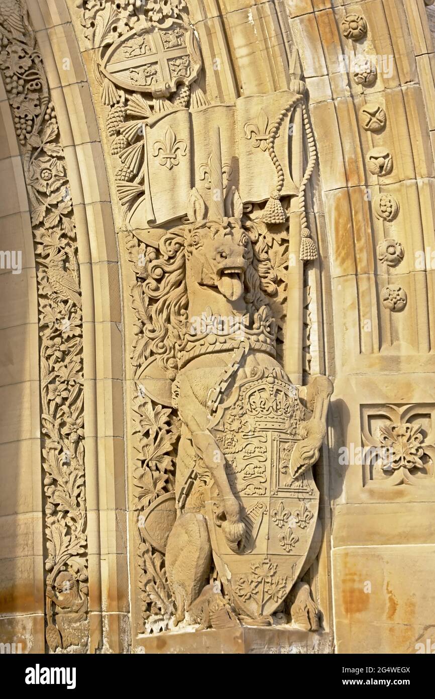 Gothic revival fantasy decoration, bas relief stone carving of a unicorn holidng a banner and a shield, surrounded by flower ribbons, found in Parliam Stock Photo