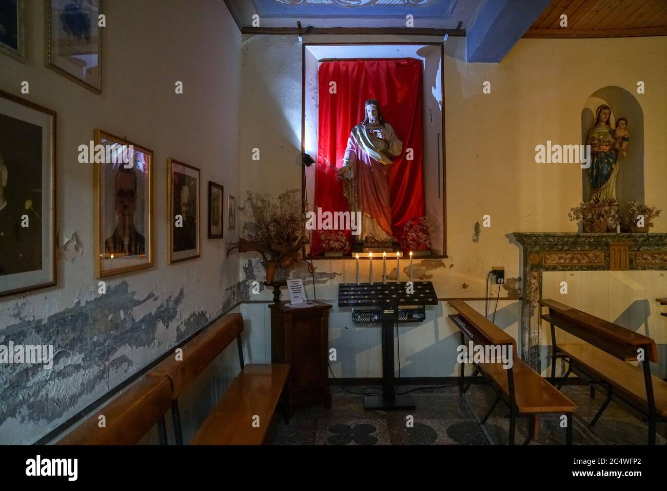 Pella - 07/12/2020: interior of small church with Christ statue and votive candles Stock Photo
