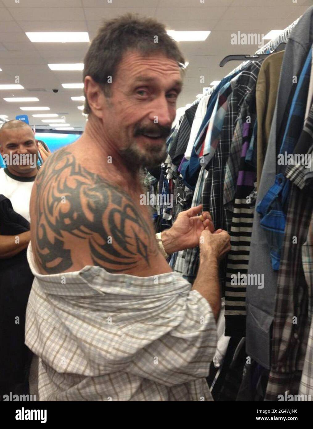 Miami, USA. 13th Dec, 2012. John McAfee shows off his tatoo while shopping in South Beach, Miami, on Thursday, December 13, 2012. John McAfee, the controversial guru of computer anti-virus software, denied Thursday in Miami Beach that he's been interviewed by Internal Revenue Service and FBI agents after arriving the previous night following deportation from Guatemala. (Photo by Anna Edgerton/Miami Herald/MCT/Sipa USA) Credit: Sipa USA/Alamy Live News Stock Photo