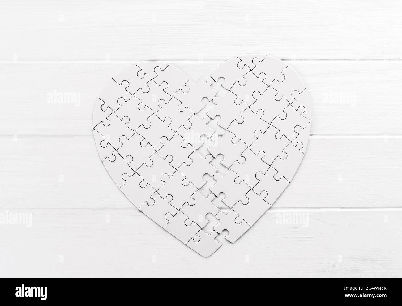 Bold heart shaped puzzle on white table Stock Photo