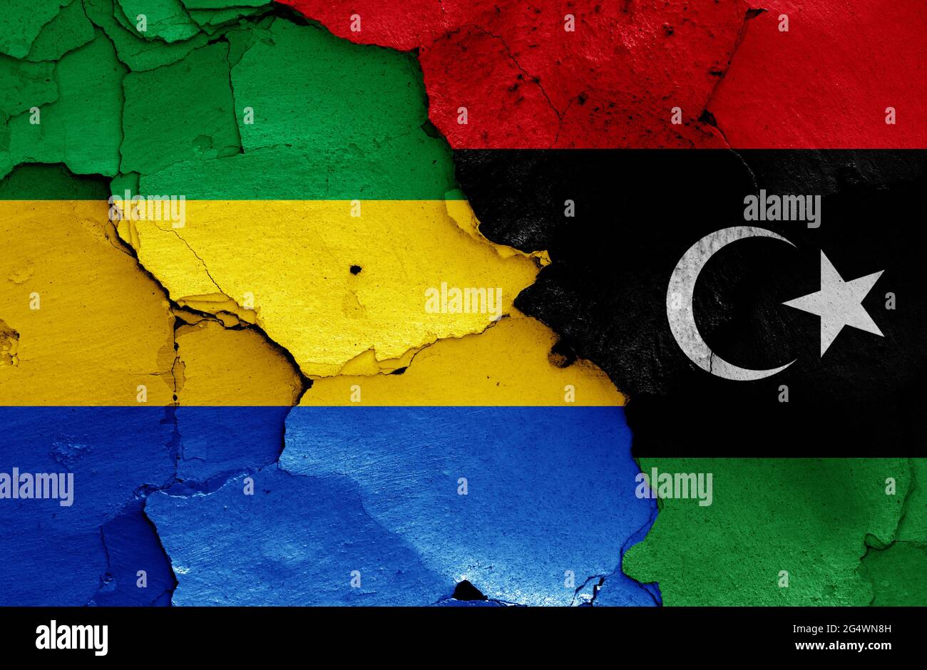 flags of Gabon and Libya painted on cracked wall Stock Photo