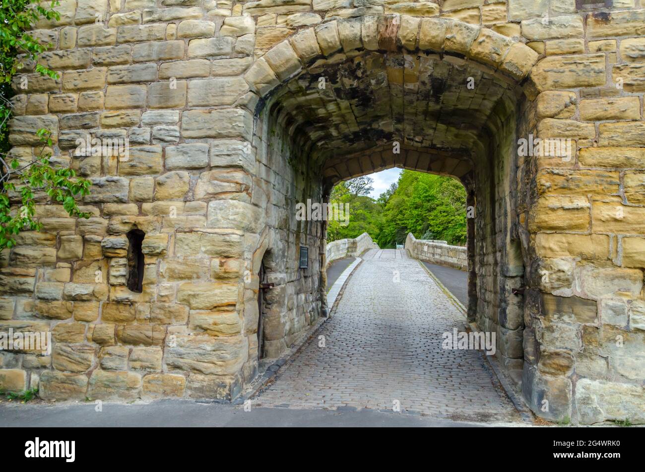 View Through Warkworth Bridge Gateway and across Warkworth Bridge at Warkworth, Northumberland.  The Medieval Bridge and Archway are Grade II Listed. Stock Photo