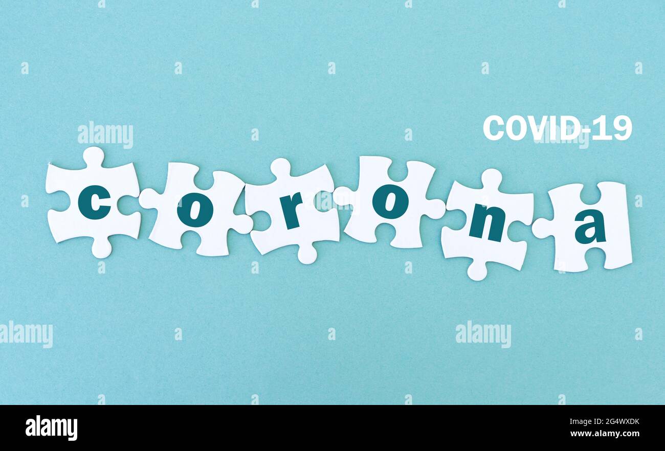Jigsaw puzzle pieces with corona, blue background Stock Photo