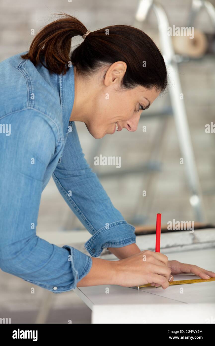 female repairman carpenter concentrated on her work Stock Photo