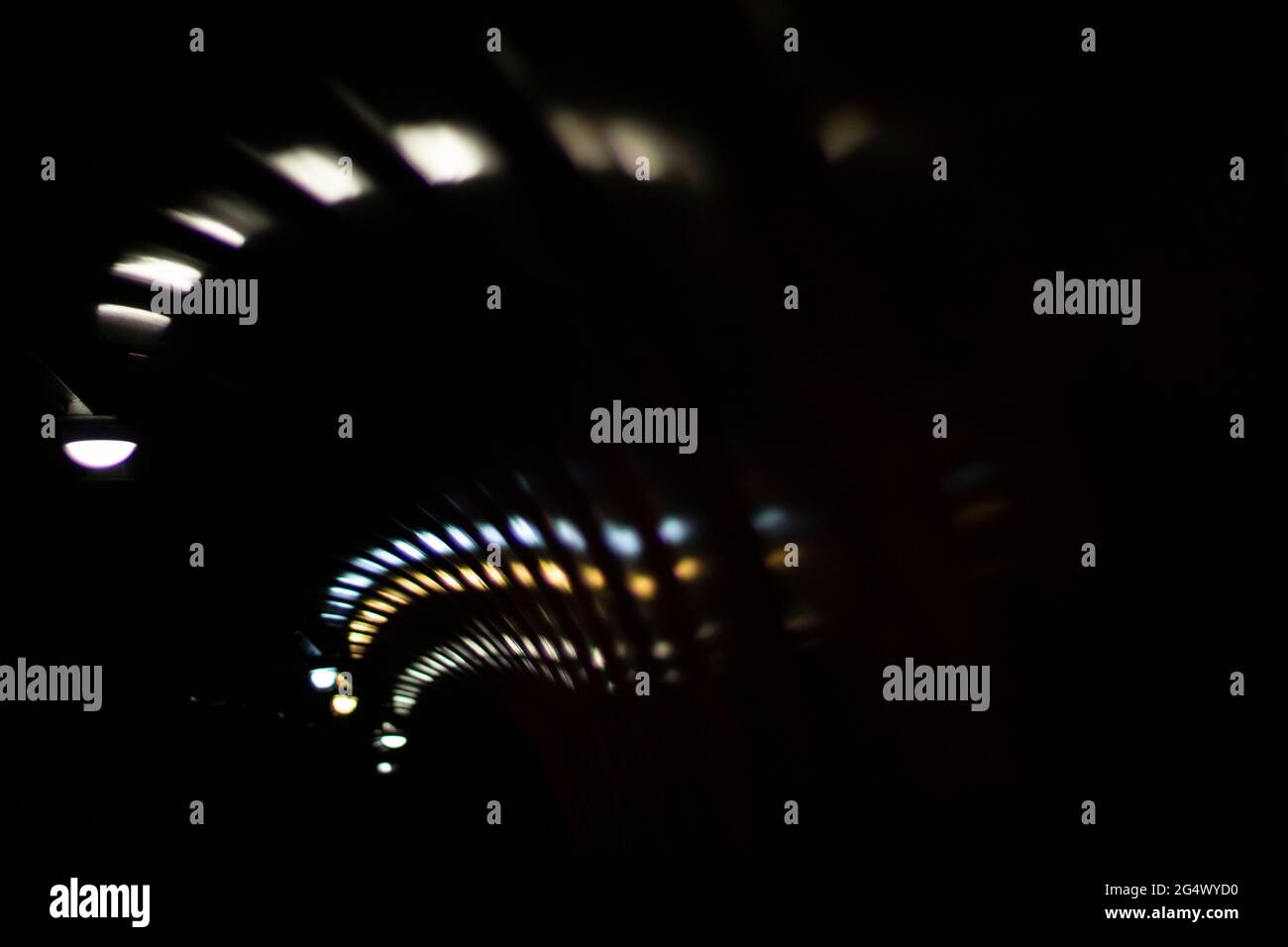 Glare of lights in the tunnel. The lights are twisting in a spiral. Reflection of light in a plastic tunnel. Stock Photo