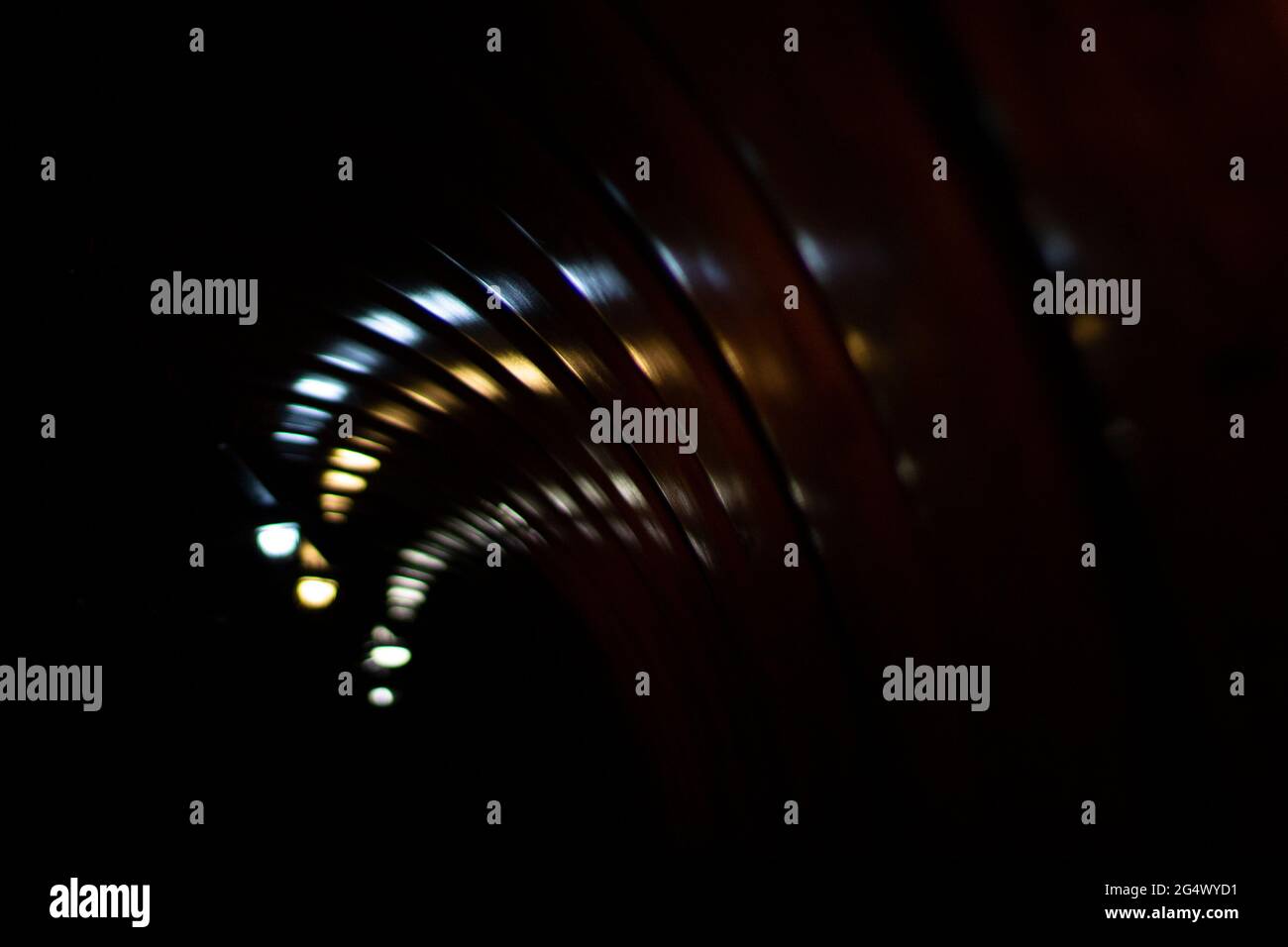 Glare of lights in the tunnel. The lights are twisting in a spiral. Reflection of light in a plastic tunnel. Stock Photo