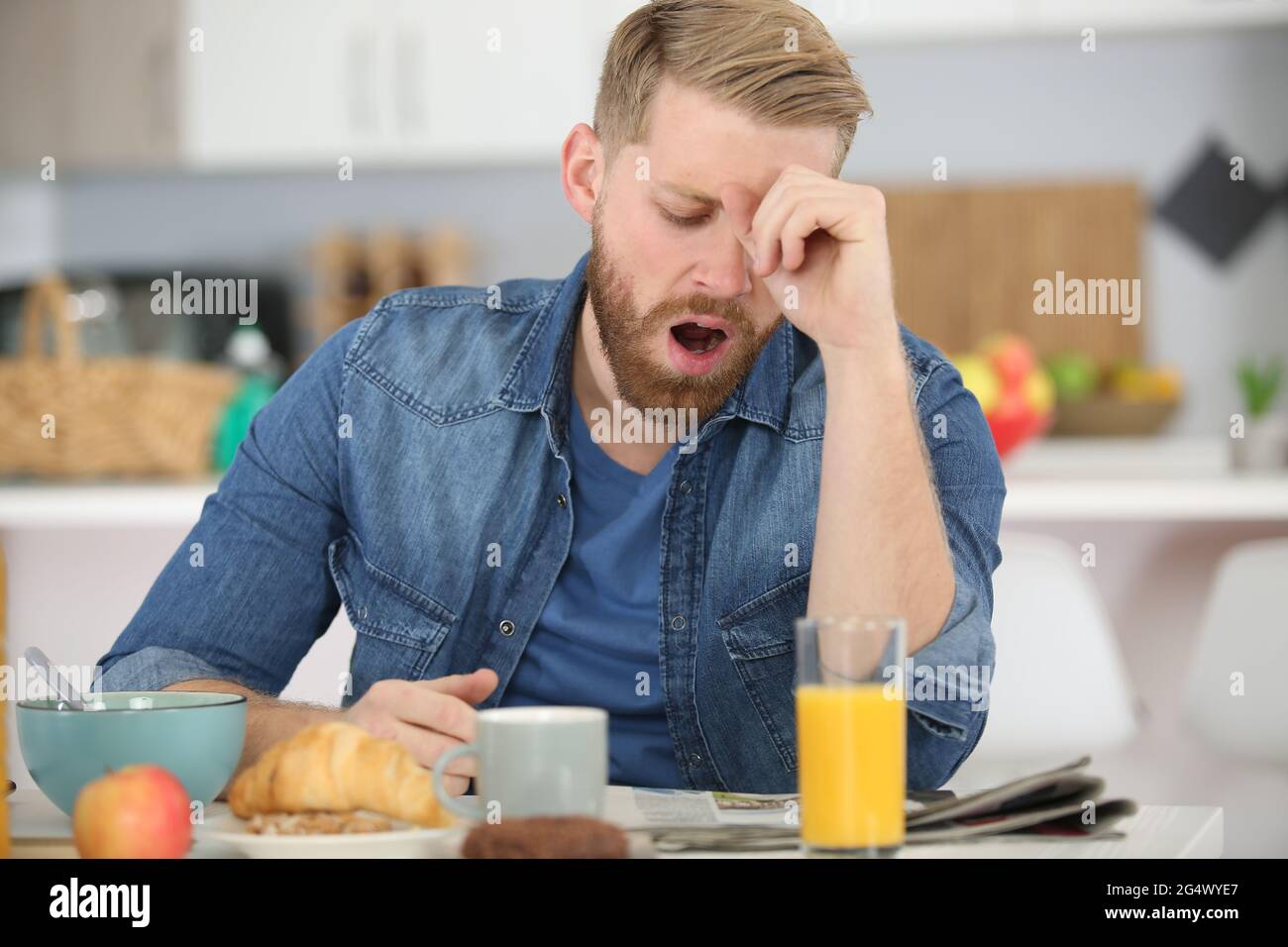 man falling asleep during his breakfast after overtime work Stock Photo