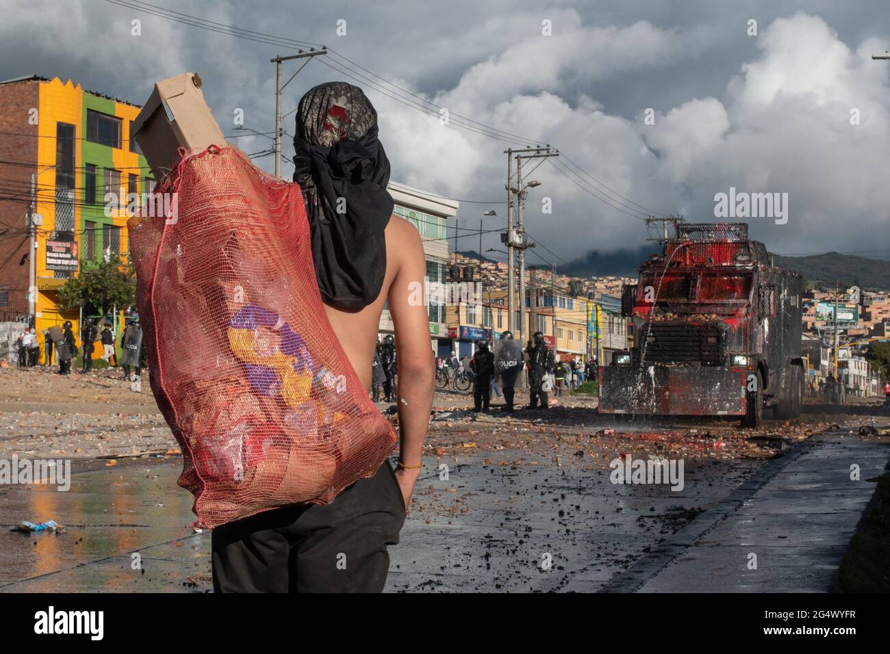 Bogota, Colombia. 21st June, 2021. A demonstrator carries debree in a rag as clashes between demonstratros and Colombia's riot police erupt anti-government protest raise in Bogota Colombia against the government of president Ivan Duque, inequalities and abuse of authority by police. Credit: Long Visual Press/Alamy Live News Stock Photo