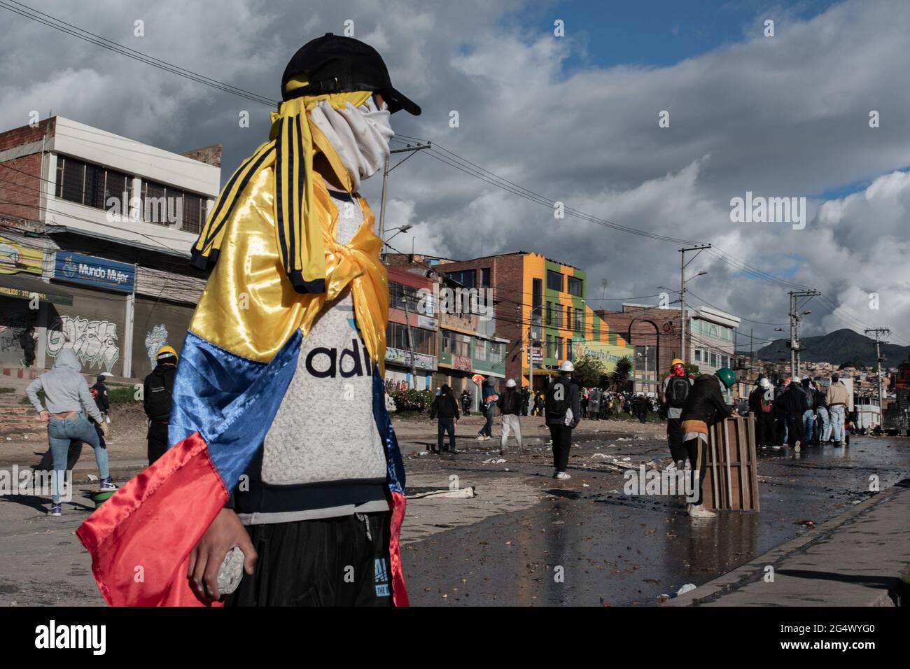 Bogota, Colombia. 21st June, 2021. A demonstrator uses a Colombian flag as a cape as clashes between demonstratros and Colombia's riot police erupt anti-government protest raise in Bogota Colombia against the government of president Ivan Duque, inequalities and abuse of authority by police. Credit: Long Visual Press/Alamy Live News Stock Photo