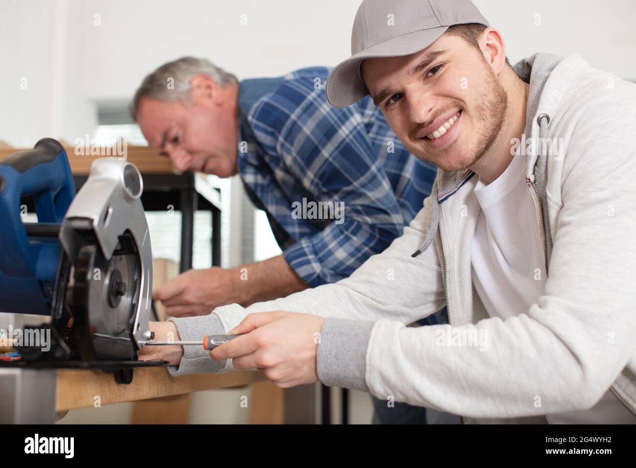 happy student and teacher in carpentry class using circular saw Stock ...