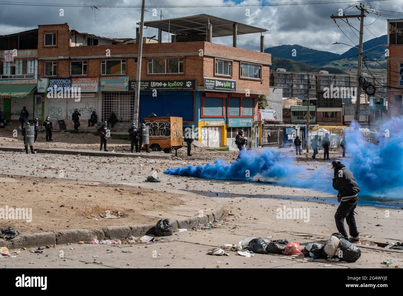 Bogota, Colombia. 21st June, 2021. A blue smoke tear gas grenade blows as clashes between demonstratros and Colombia's riot police erupt anti-government protest raise in Bogota Colombia against the government of president Ivan Duque, inequalities and abuse of authority by police. Credit: Long Visual Press/Alamy Live News Stock Photo