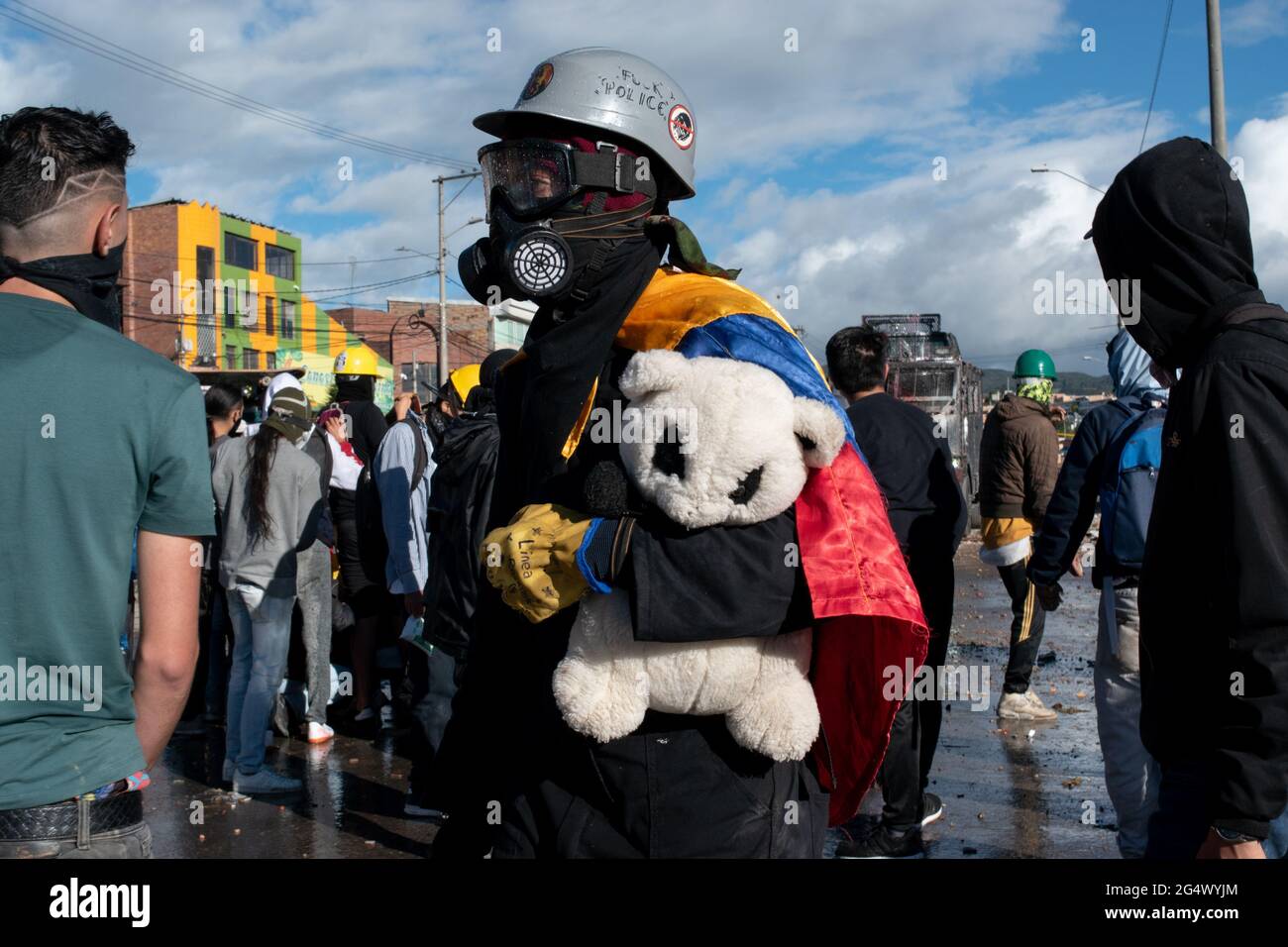 Bogota, Colombia. 21st June, 2021. A demonstrator with a Colombian flag, carries a plush bear as clashes between demonstratros and Colombia's riot police erupt anti-government protest raise in Bogota Colombia against the government of president Ivan Duque, inequalities and abuse of authority by police. Credit: Long Visual Press/Alamy Live News Stock Photo