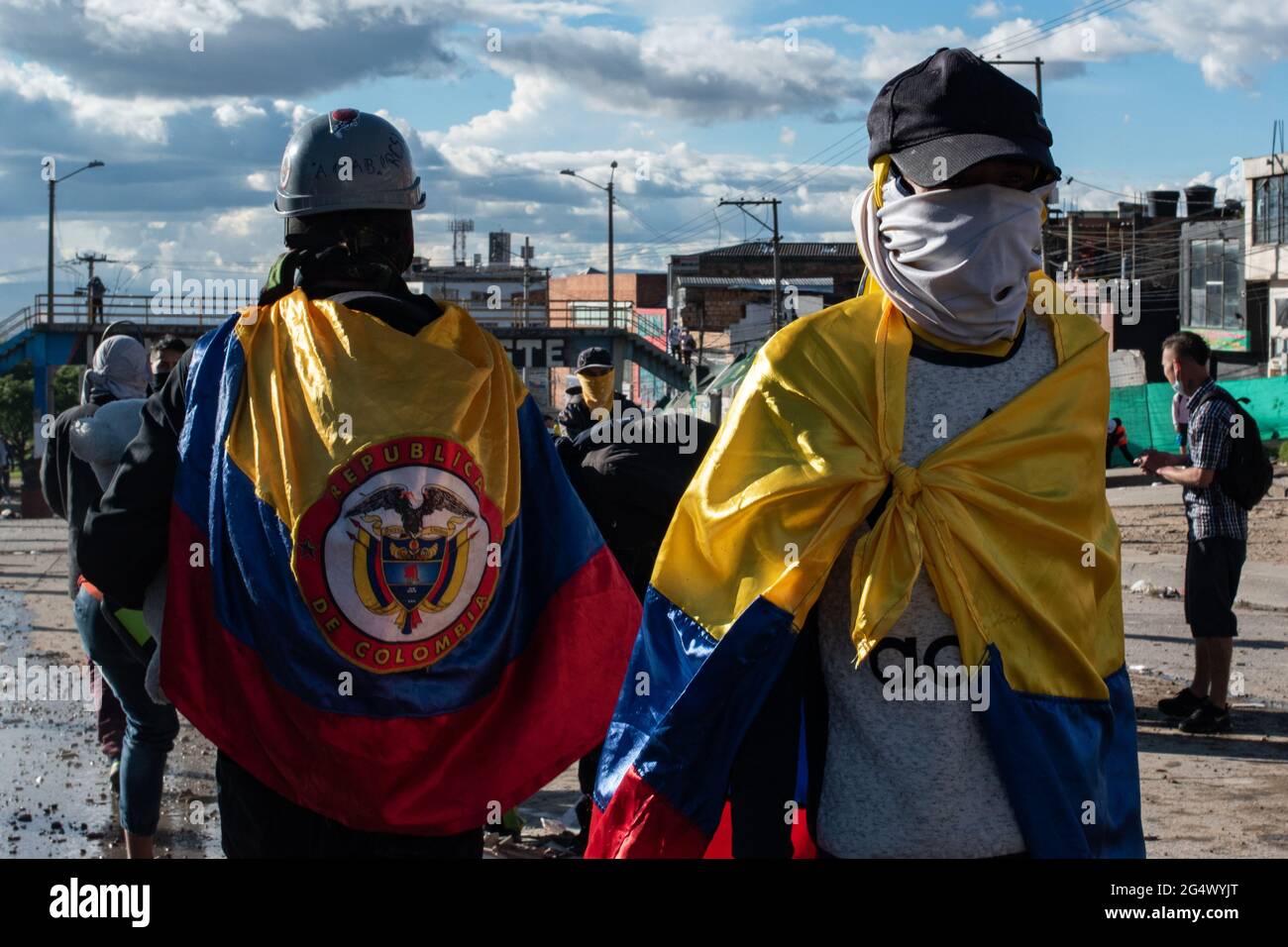 Bogota, Colombia. 21st June, 2021. Demonstrators cover their faces while using Colombia's national flag as capes as clashes between demonstratros and Colombia's riot police erupt anti-government protest raise in Bogota Colombia against the government of president Ivan Duque, inequalities and abuse of authority by police. Credit: Long Visual Press/Alamy Live News Stock Photo