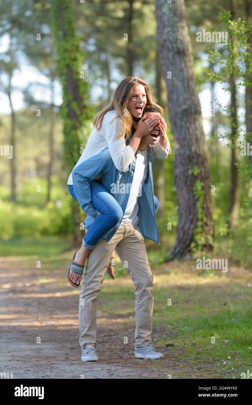 beautiful young couple enjoying a piggyback in the forest Stock Photo ...