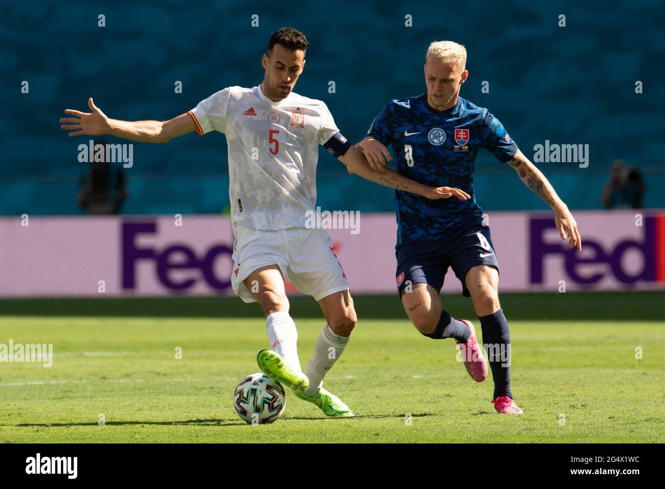 Seville, Spain. 23rd June, 2021. Spain's Sergio Busquets (L) vies with Slovakia's Ondrej Duda during the Group E match between Slovakia and Spain at the UEFA Euro 2020 in Seville, Spain, June 23, 2021. Credit: Meng Dingbo/Xinhua/Alamy Live News Stock Photo