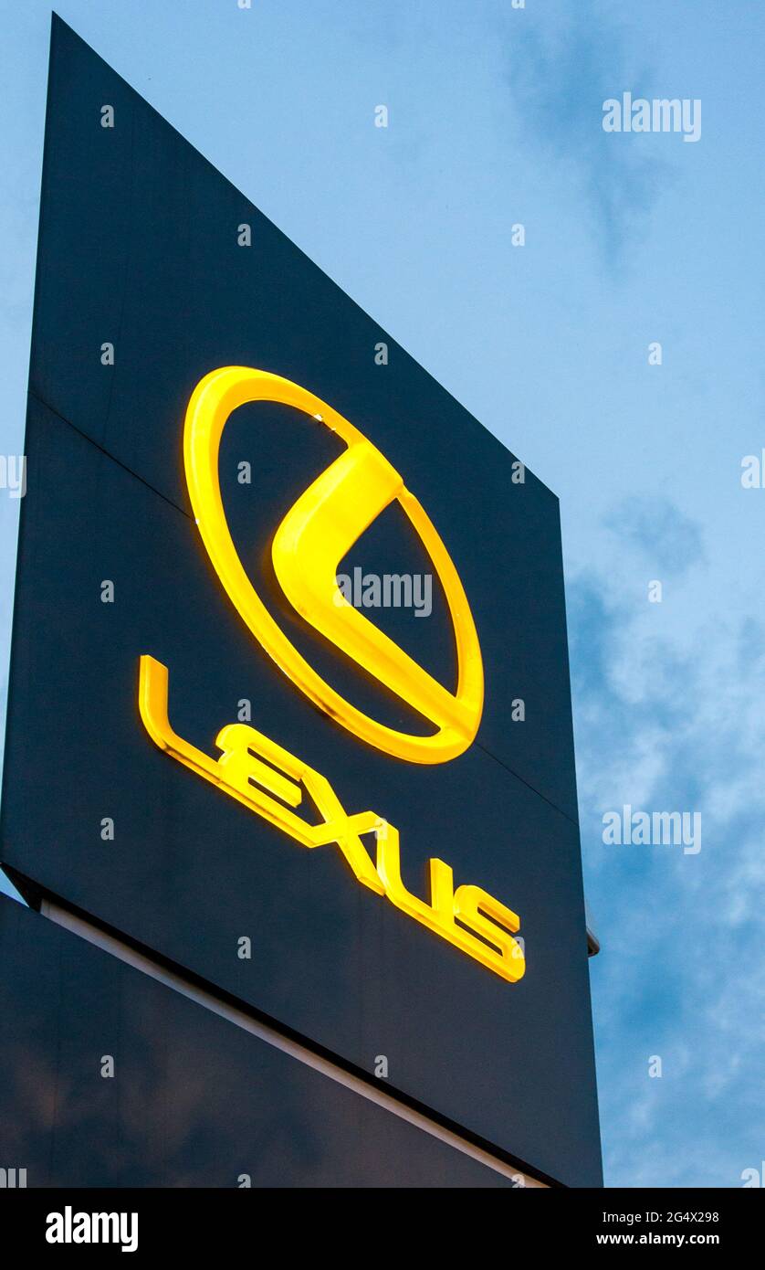 Logo of Lexus luxury cars, with the word Lexus and the circular symbol in bright yellow against a dark blue background. Stock Photo