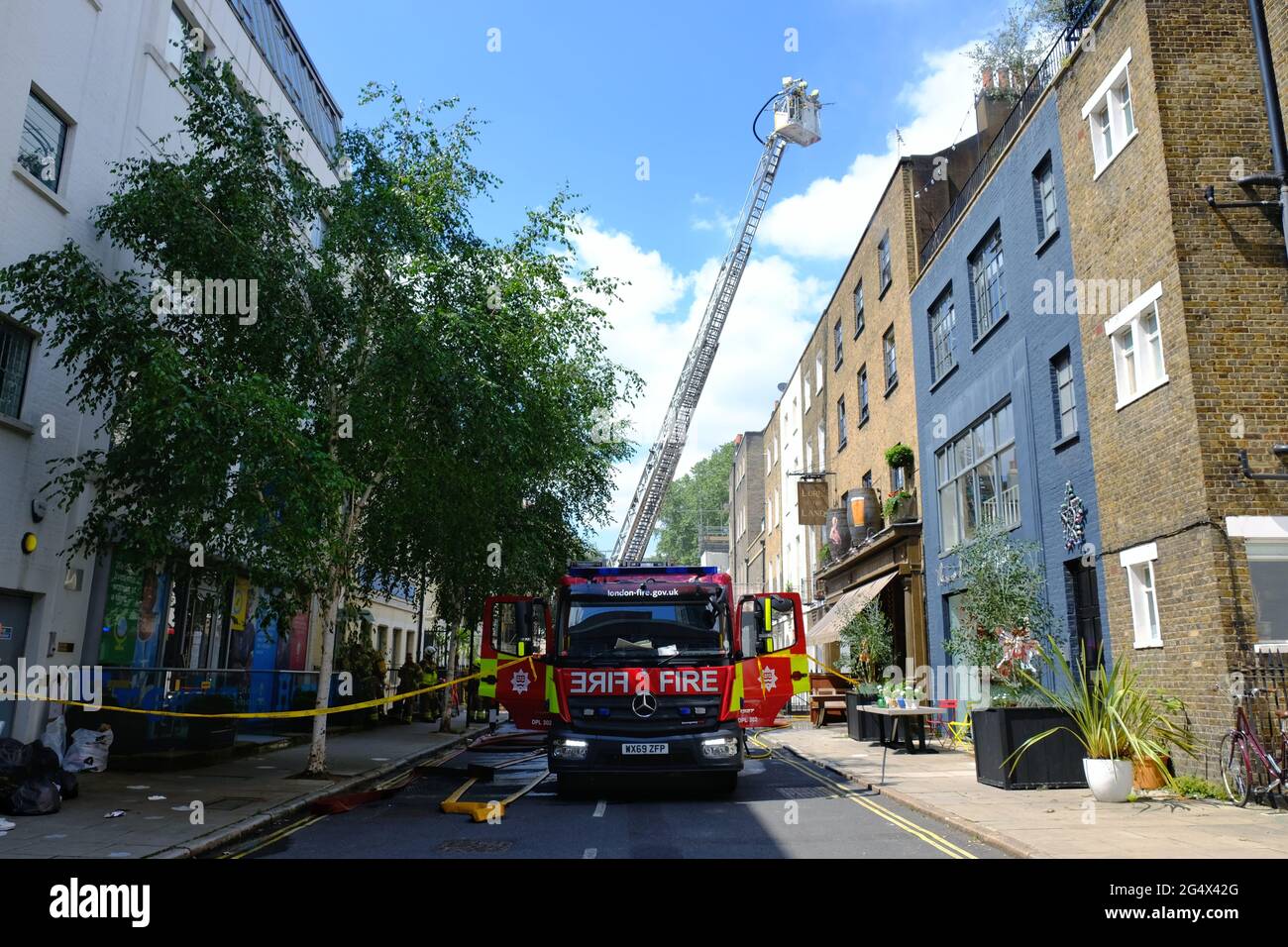 Firefighters tackle a fire at film director Guy Ritchie's pub, the Land of the Lore and were seen on a platform targeting the roof and chimney. Stock Photo