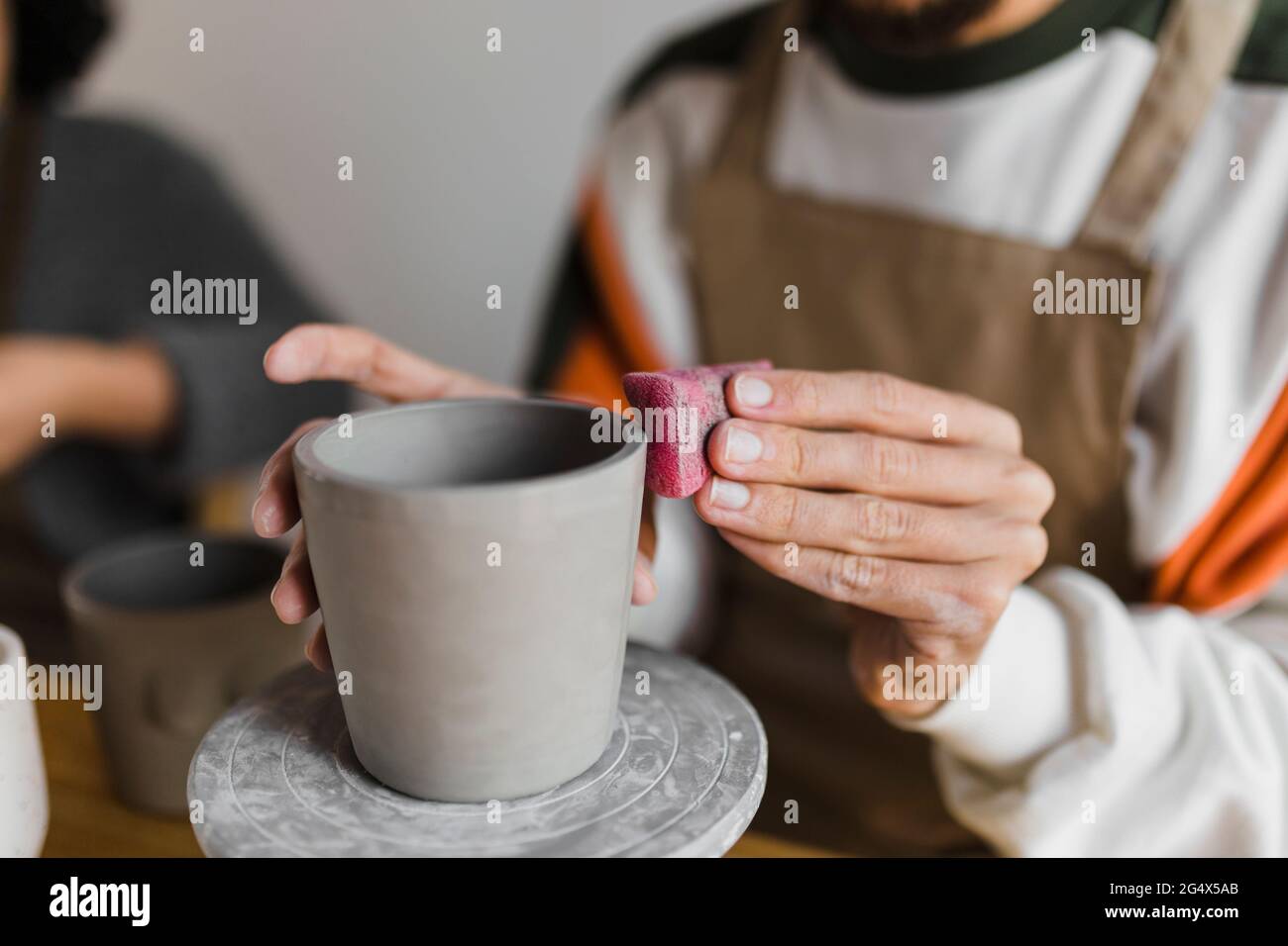 Craftsperson polishing clay container while working at Stock