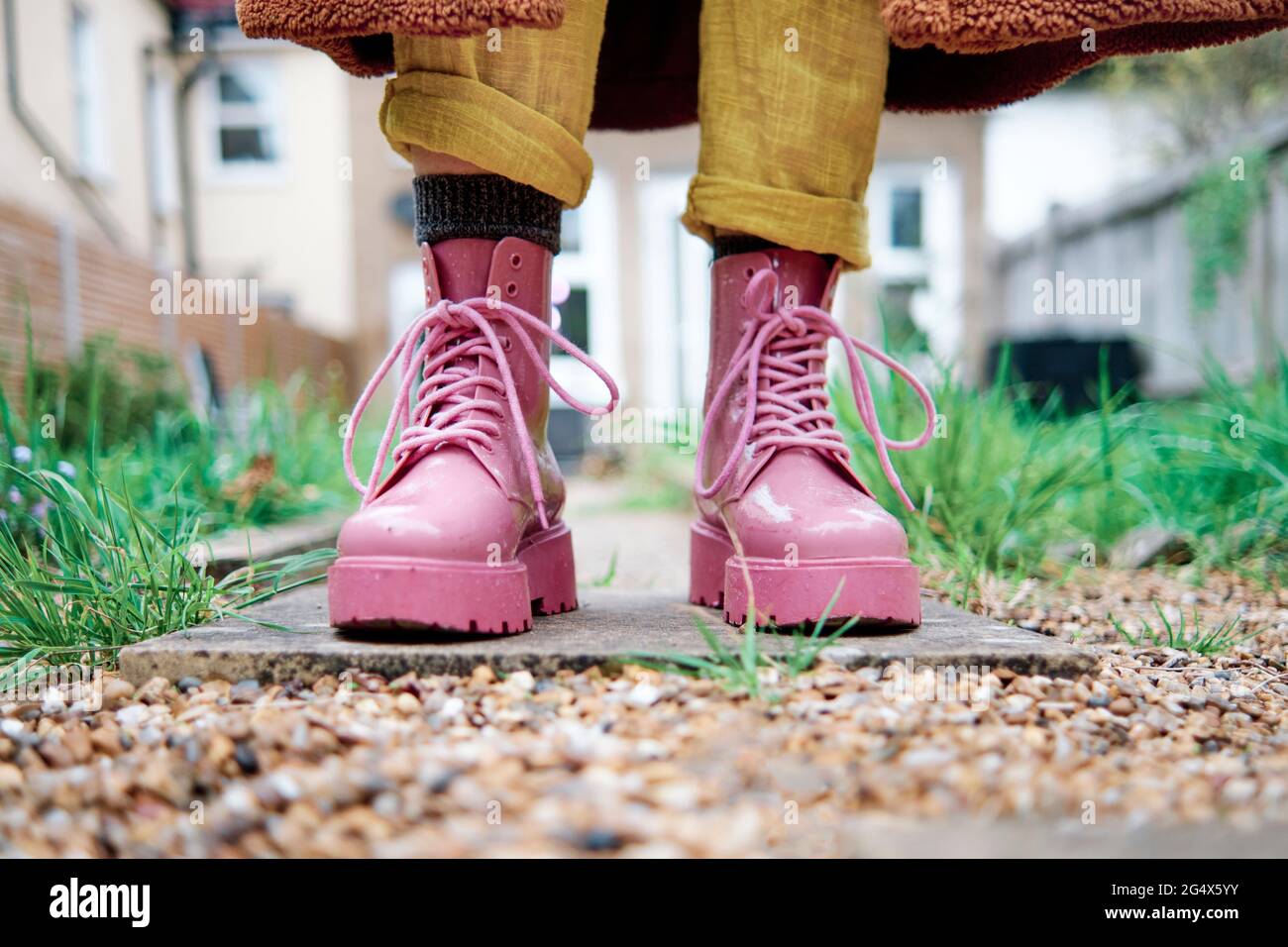 Woman with pink color shoe standing on footpath Stock Photo - Alamy