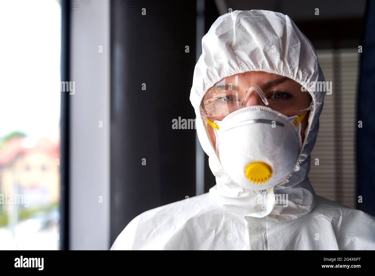 Female frontline worker wearing protective face mask at office Stock Photo