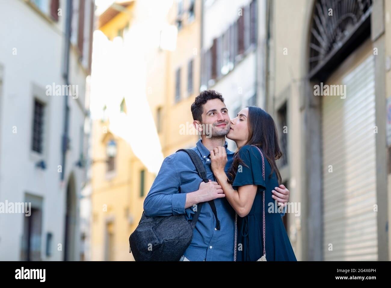 Female tourist kissing man while standing on city street Stock Photo ...
