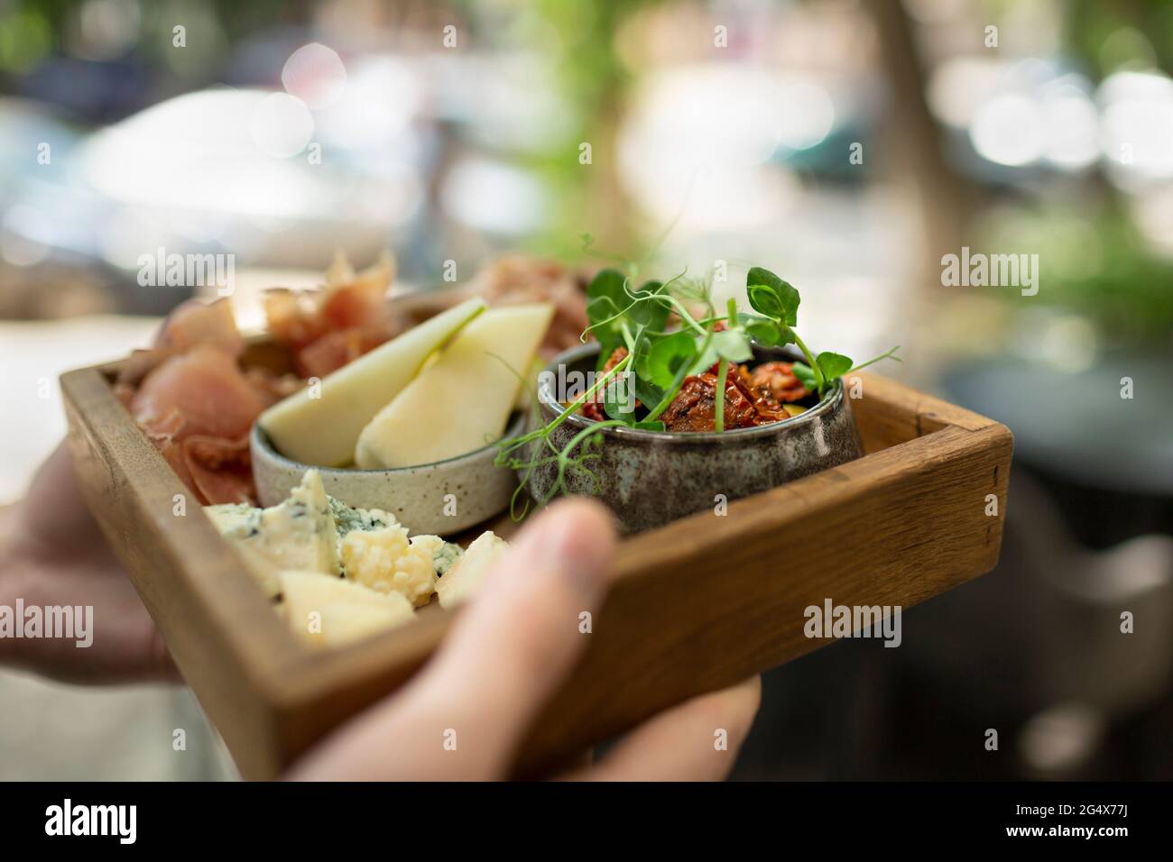 Male waiter carrying tray of food while working in restaurant Stock Photo